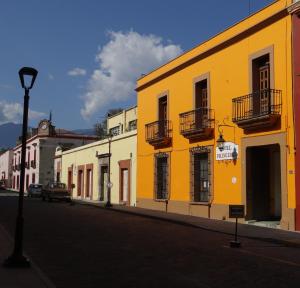 un bâtiment jaune au bord d'une rue dans l'établissement Hotel Principal, à Oaxaca