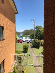 a building with a gate in front of a yard at Akuna 8 in Forster