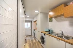 eine Küche mit einer Spüle und einer Waschmaschine in der Unterkunft Traditional Apartment with a Terrace, AC and Fast Internet in Lissabon