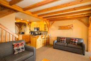 ein Wohnzimmer mit 2 Sofas und einer Küche in der Unterkunft 3 BR 3 Bath ski in ski out with private hot tub in Big White