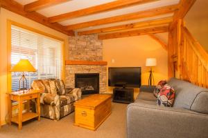 a living room with two couches and a fireplace at 3 BR 3 Bath ski in ski out with private hot tub in Big White