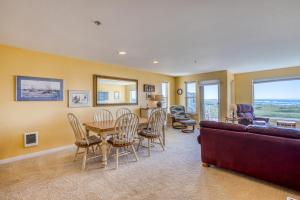 a living room with a table and chairs and a couch at Beach Views in Westport