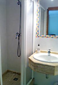 a bathroom with a shower, sink, and mirror at Hostal Del Carmen in Santander