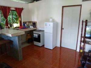 a kitchen with a white refrigerator and a counter at Zamora's House in San Juan del Sur