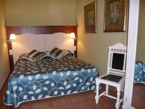 Cal Josep في Portell: غرفة نوم بسرير لحاف ازرق وبيض