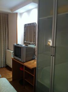 a room with a desk with a microwave and a television at Hostal Del Carmen in Santander