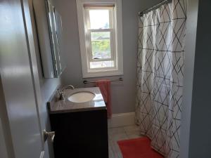 a bathroom with a sink and a shower with a window at shared house in Federal Hill in Providence