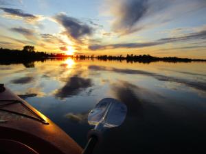 a boat on a lake with the sun setting at Sauble River Marina and Lodge Resort in Sauble Beach