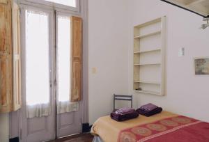 a bedroom with a bed in a room with a window at Experiencia Congreso in Buenos Aires