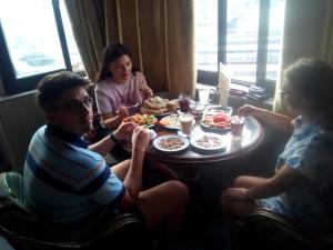 un grupo de personas sentadas alrededor de una mesa comiendo comida en Ciao Hotel Cairo, en El Cairo