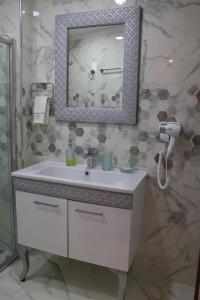 a bathroom with a white sink and a mirror at Yankı Hotel in Çekirge