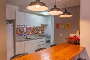 a kitchen with a wooden table with a bowl of fruit at Apartamento completo na Paradisíaca Praia dos Ingleses in Florianópolis