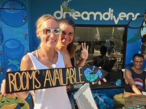 Due donne con un cartello che dice "roo aale" di Dream Divers Resort a Gili Trawangan