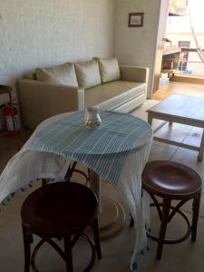 a living room with a table with two chairs and a couch at Miralejos Complejo de Apartamentos in Punta Del Diablo