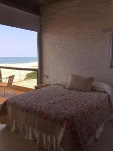 a bedroom with a bed with a view of the beach at Miralejos Complejo de Apartamentos in Punta Del Diablo