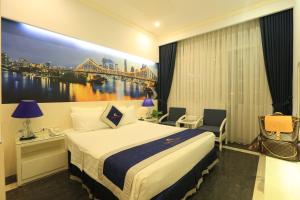 a hotel room with a bed and a painting of a bridge at Tuong Vi Hotel in Hai Phong