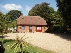 a small brick house with a gravel driveway at Clock House Cottage in Brook