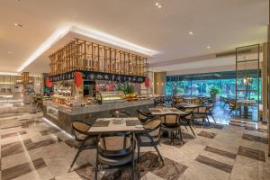 Grand Metropark Hotel Hangzhou في هانغتشو: مطعم بطاولات وكراسي وبار
