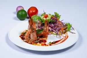 a plate of food with a salad on a table at Hon Rom Central Beach Resort in Mui Ne