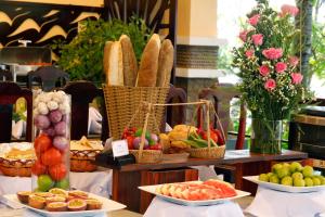 a table with baskets of bread and fruits and vegetables at Hon Rom Central Beach Resort in Mui Ne