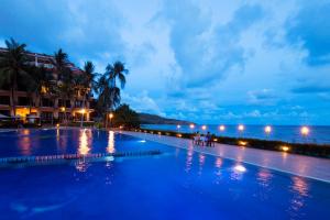 a swimming pool with a view of the ocean at night at Hon Rom Central Beach Resort in Mui Ne