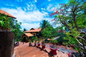 a group of potted plants sitting on a brick patio at Hon Rom Central Beach Resort in Mui Ne