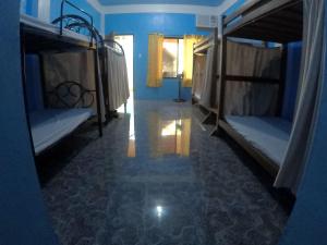 a blue room with two bunk beds and a hallway at Carillo guest house in Coron