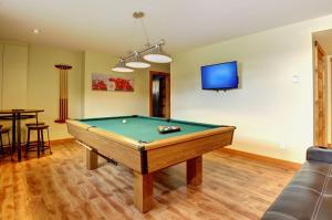 a living room with a pool table and a tv at 36- Chalet à louer à Stoneham in Stoneham