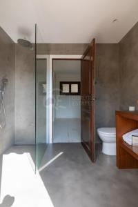 カロンジェにあるMasia Tahitiのバスルーム(ガラス張りのシャワー、トイレ付)