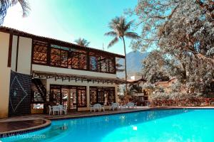 a resort with a swimming pool and a building at Casa Canto do Mar Maresias 2 in Maresias