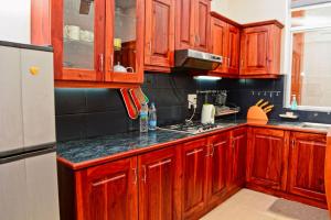 a kitchen with wooden cabinets and a refrigerator at Furnished apartment at Colombo suburbs Nawala in Rajagiriya