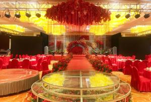 een grote feestzaal met rode stoelen en een tafel bij Days Hotel & Suites by Wyndham Jiangsu Xinyi in Xinyi