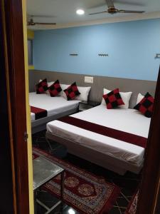 two beds are in a room with sidx sidx sidx sidx at Gayathri Stay in Kanchipuram +10 photos
