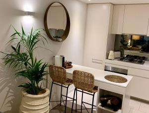 una cocina con encimera con sillas y una planta en Boutique Abode 314 en Melbourne