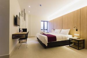 a bedroom with a bed and a desk and a desk at GM Hotel Kuantan in Kuantan
