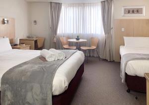 a hotel room with two beds and a table at Airport Ascot Motel in Brisbane