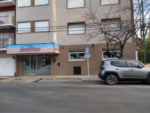 Un coche plateado aparcado frente a un edificio en Hotel Avellino, en Mar del Plata