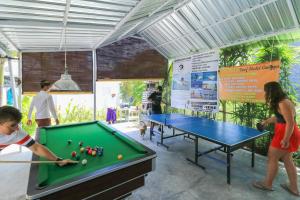 a group of people playing a game of pool at Margarita Surf Hostel in Canggu