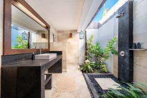 ein Badezimmer mit Waschbecken und Spiegel in der Unterkunft Tír na nÓg Beachfront Resort in Gili Trawangan