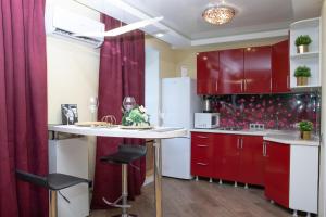 a kitchen with red cabinets and a white refrigerator at 1-к квартира 9 января, 6 in Kemerovo