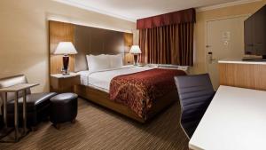 a hotel room with a bed and a desk at Best Western Hollywood Plaza Inn Hotel - Hollywood Walk of Fame LA in Los Angeles