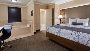 a hotel room with a bed and a bath tub at Best Western Hollywood Plaza Inn Hotel - Hollywood Walk of Fame LA in Los Angeles