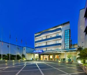 un hotel con un parcheggio di fronte di Best Western Hotel Ferrari a Nola