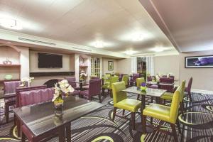 a restaurant with tables and chairs and a flat screen tv at Days Inn by Wyndham Gainesville Florida in Gainesville