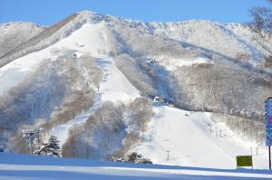 a snow covered mountain with a ski slope with a ski lift at Annex Aburaya in Iiyama