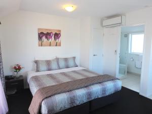 a bedroom with a bed and a bathroom at 101 Stars Motel in Christchurch