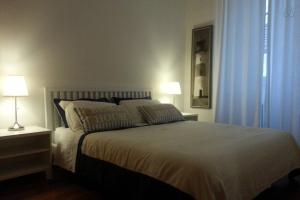 a bedroom with a large white bed with two lamps at Il Borgo in Trieste