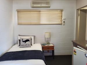 多尔比Windsor Hotel Motel Dalby的一间有床和窗户的小卧室