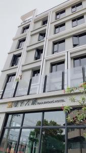 a tall white building with a sign on it at Tian Zhong Hotel in Tianzhong