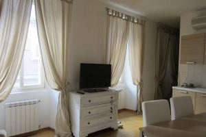 a living room with a tv on a dresser with curtains at Il Borgo in Trieste